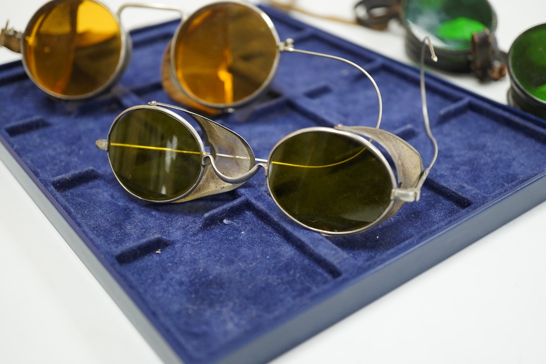 A pair of Wellsworth safety goggles with mesh sides, a pair of green tinted safety goggles with mesh sides, cased, and a pair of mesh wire sided safety spectacles with green tinted lenses (3)